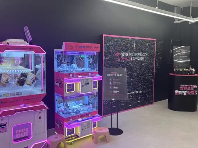 Pop-up store with pink-lit claw machines and a guestbook wall
