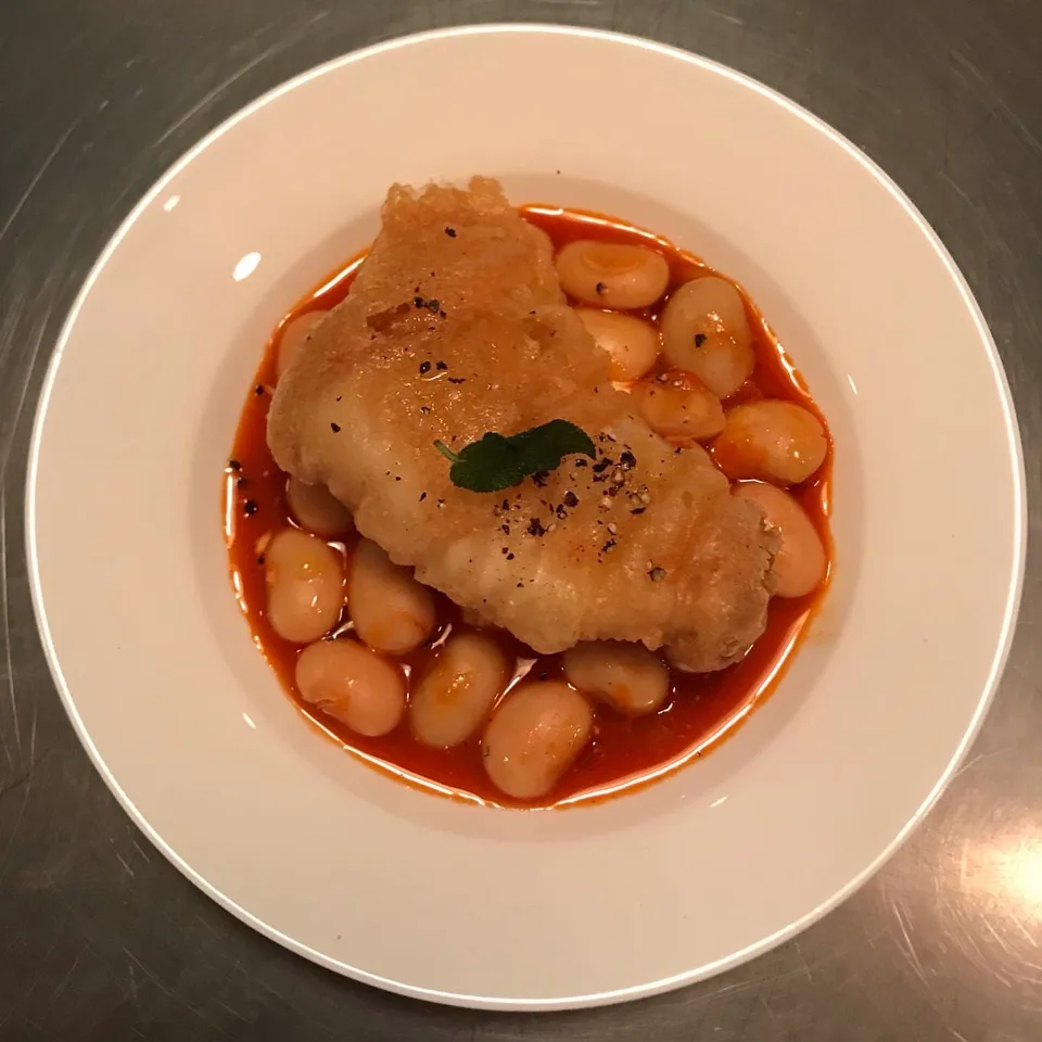 토마토 소스와 흰 강낭콩 위에 튀긴 생선을 올린 세이지의 요리