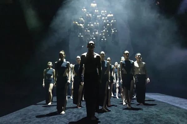 Dancers performing on a dark stage
