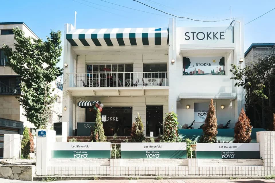 White two-storey pop-up building with a striped awning