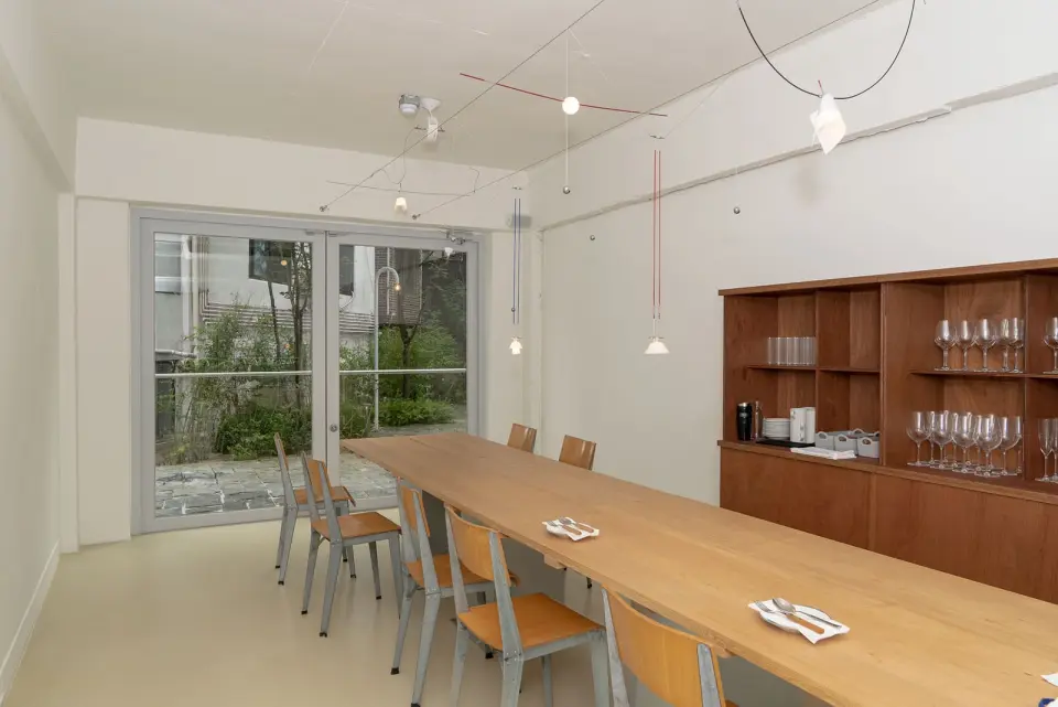 Interior with a long wooden table and pendant lights